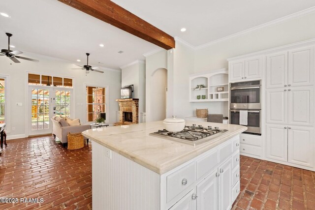 105 Oak Aly, Lafayette, LA 70508 - kitchen featuring stainless steel double oven, brick flooring, gas stovetop, a ceiling fan, and open floor plan