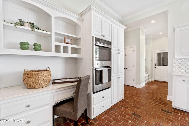 105 Oak Aly, Lafayette, LA 70508 - kitchen featuring double oven, crown molding, white cabinetry, light countertops, and brick flooring