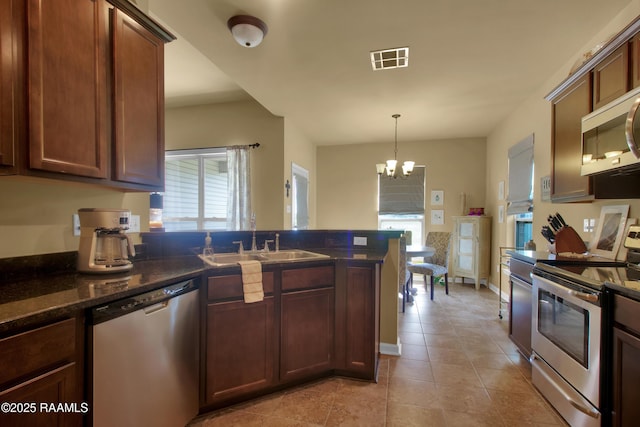 205 Broland Dr, Duson, LA 70529 - kitchen with stainless steel appliances, a sink, a peninsula, a chandelier, and light tile patterned floors