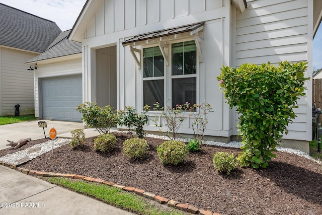 9036 Stonecroft Ave, Baton Rouge, LA 70810 - view of front of property with board and batten siding, driveway, an attached garage, and roof with shingles
