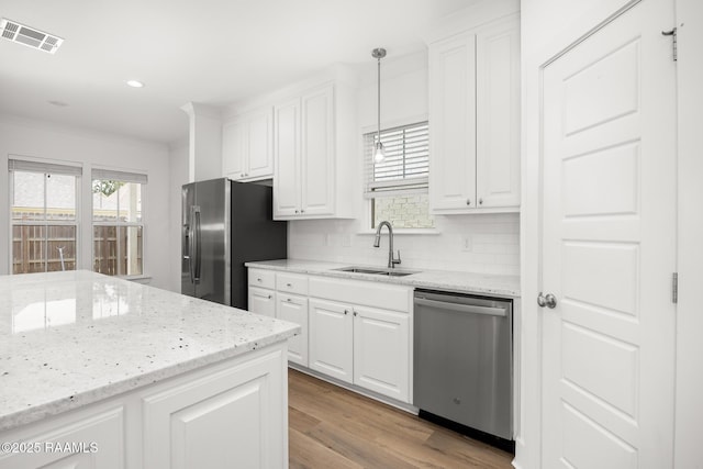 9036 Stonecroft Ave, Baton Rouge, LA 70810 - kitchen featuring appliances with stainless steel finishes, a sink, white cabinets, tasteful backsplash, and recessed lighting