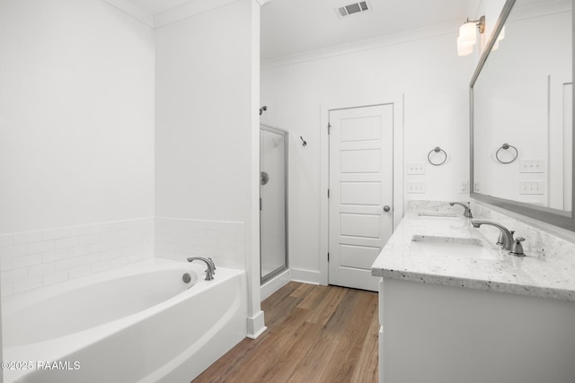 9036 Stonecroft Ave, Baton Rouge, LA 70810 - bathroom featuring a bath, ornamental molding, double vanity, wood finished floors, and a stall shower