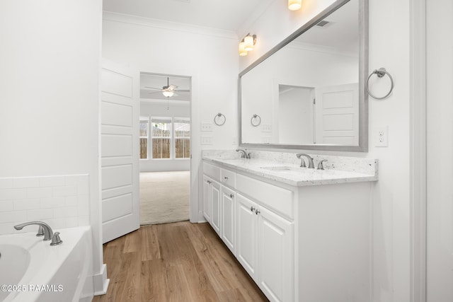 9036 Stonecroft Ave, Baton Rouge, LA 70810 - full bath with crown molding, double vanity, a ceiling fan, a bath, and wood finished floors