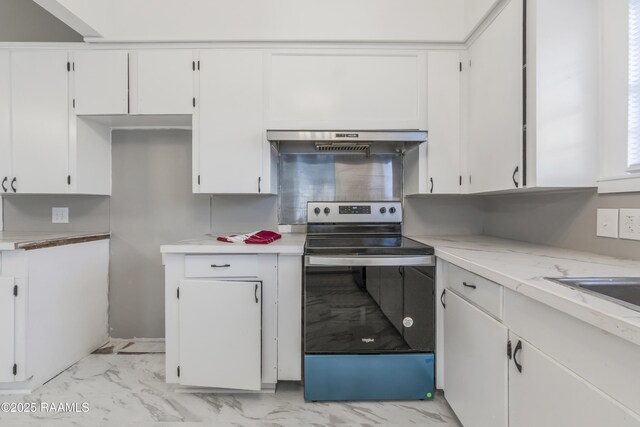 1323 Tarleton, Jeanerette, LA 70544 - kitchen featuring stainless steel electric range oven, under cabinet range hood, light marble finish floors, light countertops, and white cabinets