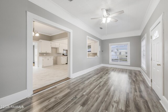 1323 Tarleton, Jeanerette, LA 70544 - unfurnished living room with wood finished floors, ornamental molding, ceiling fan, baseboards, and a chandelier
