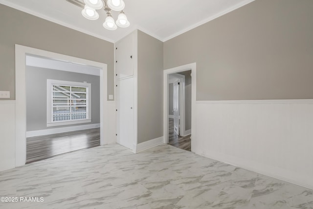 1323 Tarleton, Jeanerette, LA 70544 - empty room featuring marble finish flooring, a chandelier, ornamental molding, and wainscoting