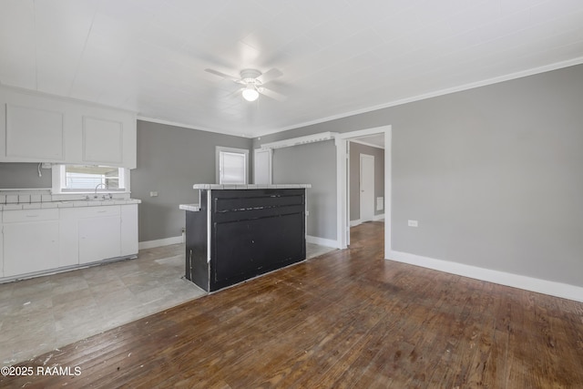 1323 Tarleton, Jeanerette, LA 70544 - kitchen featuring white cabinetry, a sink, light countertops, ceiling fan, and crown molding