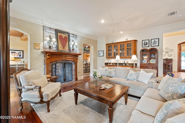 103 Masterspoint Dr, Broussard, LA 70518 - living area with arched walkways, a brick fireplace, ornamental molding, wood finished floors, and recessed lighting