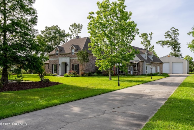 40400 Abby James Rd, Prairieville, LA 70769 - view of front facade with stone siding, a garage, a front yard, a chimney, and an outdoor structure