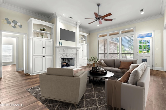 40400 Abby James Rd, Prairieville, LA 70769 - living room featuring a stone fireplace, ceiling fan, dark wood-style floors, crown molding, and baseboards