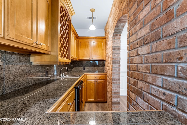 40400 Abby James Rd, Prairieville, LA 70769 - kitchen featuring tile countertops, tasteful backsplash, decorative light fixtures, a sink, and brown cabinets