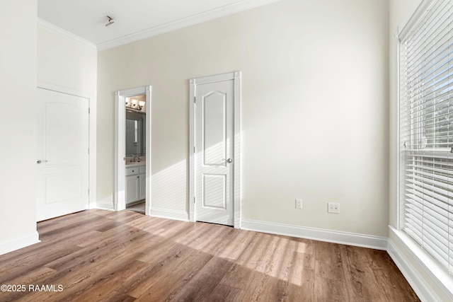 40400 Abby James Rd, Prairieville, LA 70769 - unfurnished bedroom with wood finished floors, ornamental molding, multiple windows, baseboards, and connected bathroom