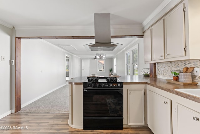 1617 Oscar St, Abbeville, LA 70510 - kitchen featuring black gas range, island exhaust hood, a peninsula, light wood-style flooring, and crown molding