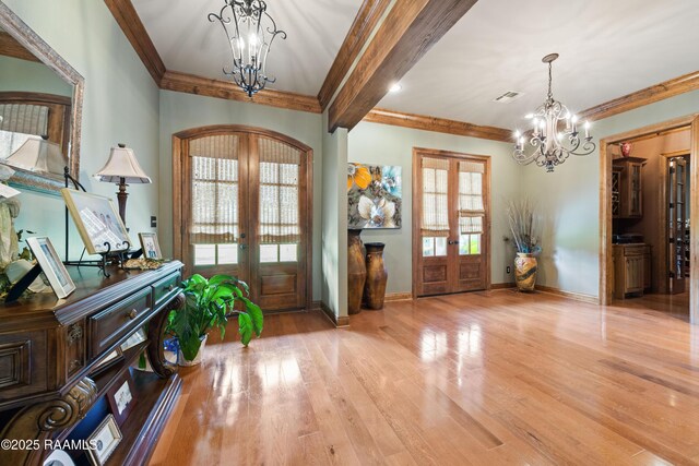 124 Edmund Ln, Eunice, LA 70535 - entrance foyer with french doors, a chandelier, crown molding, wood finished floors, and baseboards