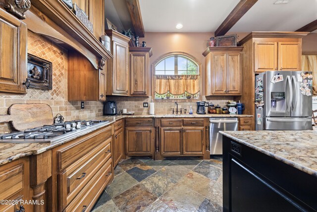 124 Edmund Ln, Eunice, LA 70535 - kitchen with appliances with stainless steel finishes, a sink, dark stone finish flooring, tasteful backsplash, and beamed ceiling