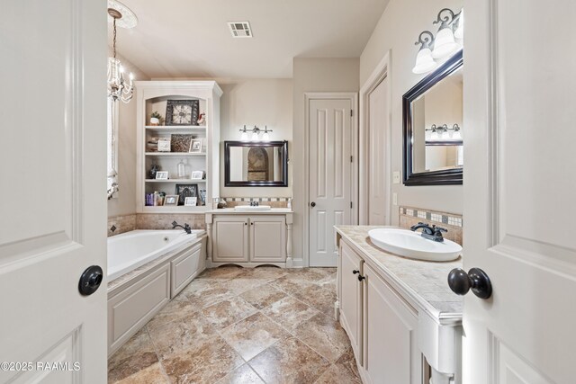 124 Edmund Ln, Eunice, LA 70535 - bathroom featuring two vanities and a garden tub