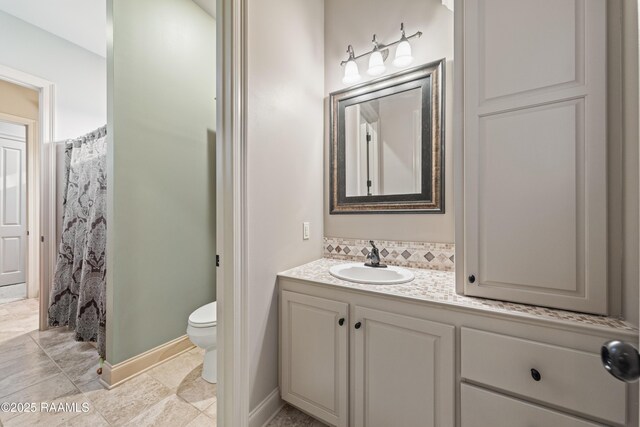 124 Edmund Ln, Eunice, LA 70535 - bathroom featuring toilet, vanity, and baseboards