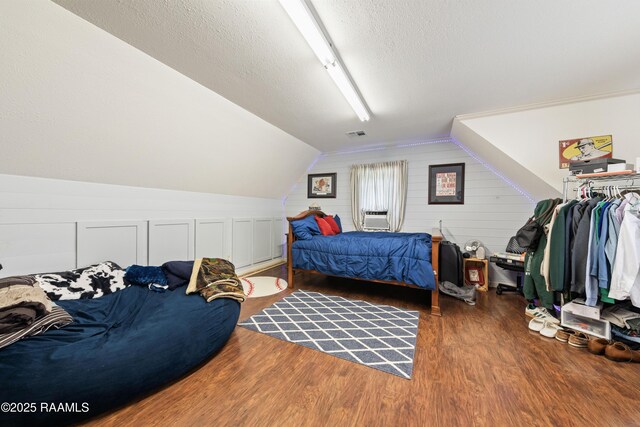 124 Edmund Ln, Eunice, LA 70535 - bedroom with wood finished floors, lofted ceiling, a textured ceiling, and cooling unit