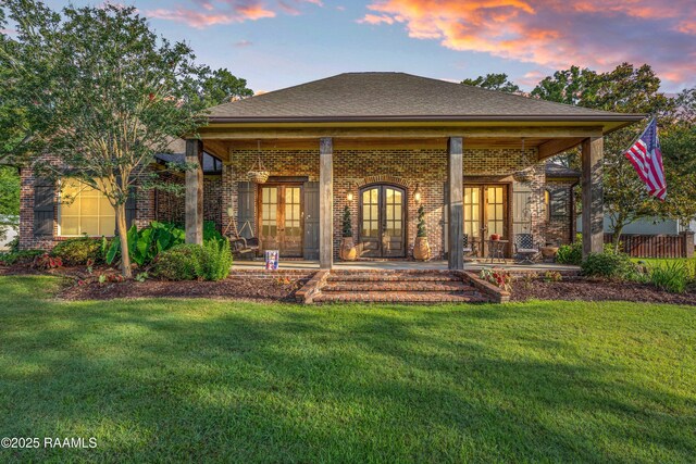 124 Edmund Ln, Eunice, LA 70535 - rear view of house with french doors, brick siding, a yard, a patio area, and roof with shingles