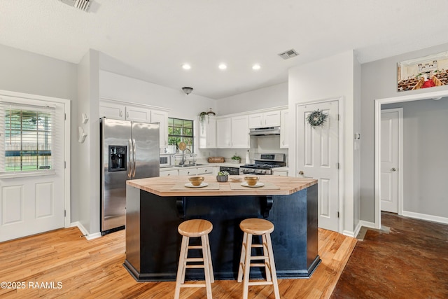 107 Westpointe Cir, Lafayette, LA 70506 - kitchen with appliances with stainless steel finishes, under cabinet range hood, a kitchen island, wood counters, and recessed lighting