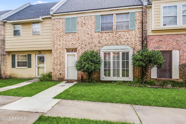 1314 Dulles Dr Unit F, Lafayette, LA 70506 - townhome / multi-family property with a front yard, brick siding, and a shingled roof