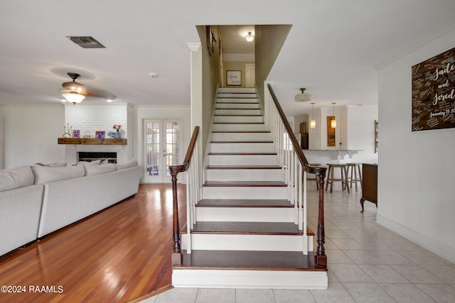 1012 Elsie Cir, Breaux Bridge, LA 70517 - staircase featuring a large fireplace, crown molding, baseboards, tile patterned flooring, and ceiling fan