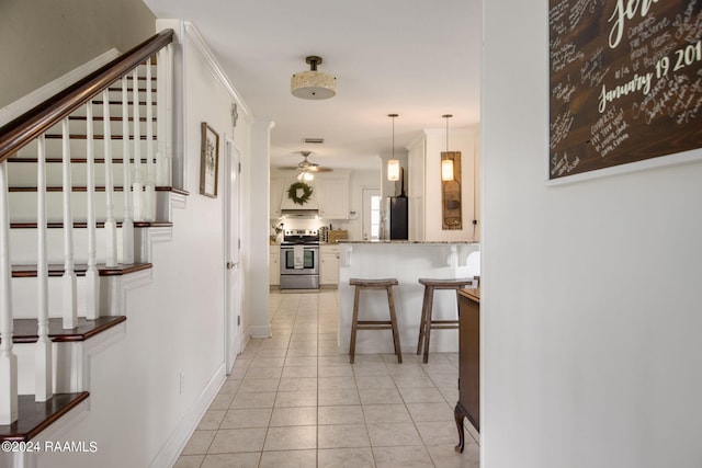 1012 Elsie Cir, Breaux Bridge, LA 70517 - corridor featuring stairway, light tile patterned floors, baseboards, and crown molding