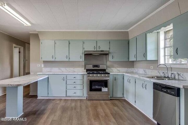 650 Juanita St, Eunice, LA 70535 - kitchen with stainless steel appliances, a sink, under cabinet range hood, dark wood-style flooring, and ornamental molding
