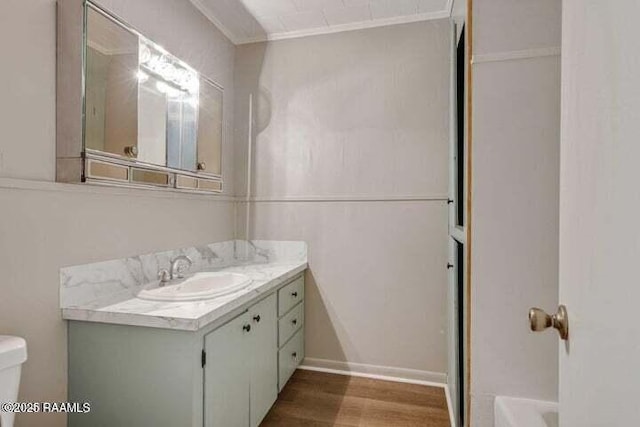 650 Juanita St, Eunice, LA 70535 - bathroom with toilet, vanity, wood finished floors, and ornamental molding