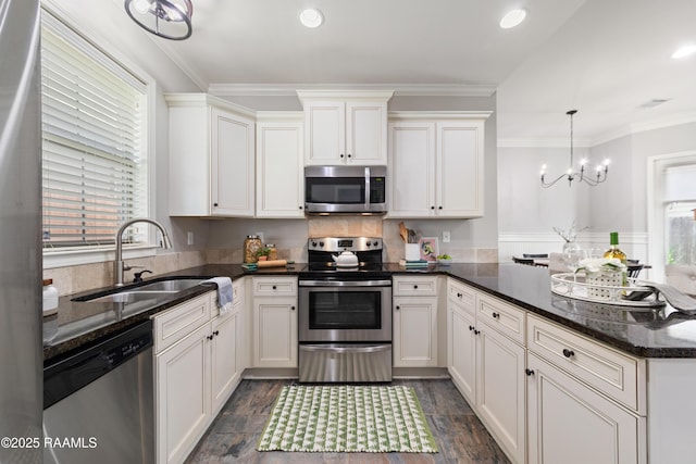 710 Highland View Dr, Youngsville, LA 70592 - kitchen with appliances with stainless steel finishes, a sink, a peninsula, crown molding, and dark stone countertops
