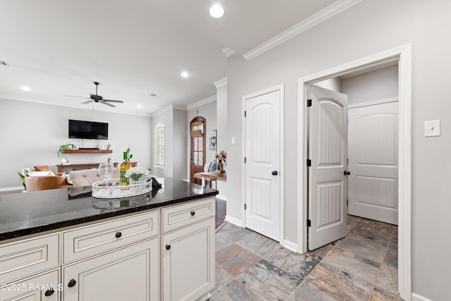 710 Highland View Dr, Youngsville, LA 70592 - kitchen with ornamental molding, ceiling fan, light stone finish flooring, baseboards, and dark stone counters