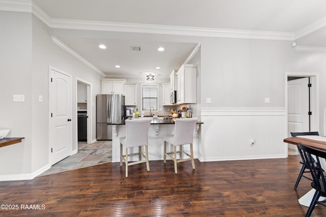 710 Highland View Dr, Youngsville, LA 70592 - kitchen featuring appliances with stainless steel finishes, a kitchen bar, a sink, a peninsula, and crown molding
