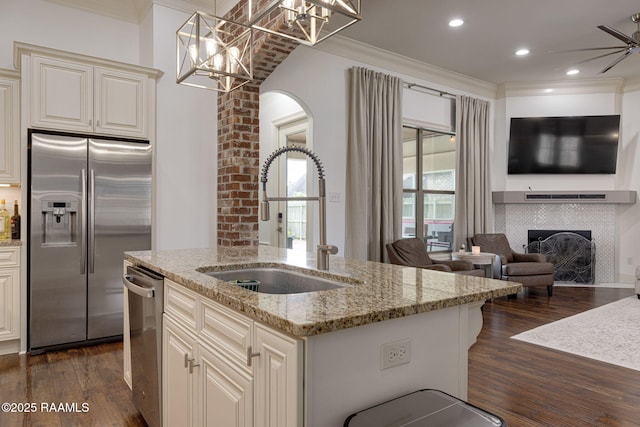 105 Hazy River Way, Lafayette, LA 70508 - kitchen with appliances with stainless steel finishes, a sink, crown molding, a tile fireplace, and dark wood-type flooring