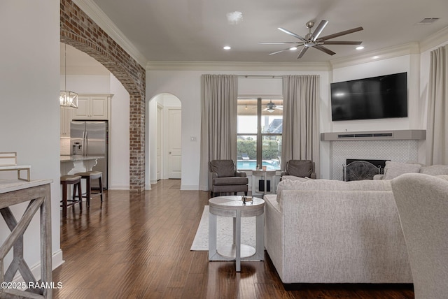 105 Hazy River Way, Lafayette, LA 70508 - living area with ceiling fan, arched walkways, a fireplace, dark wood-style floors, and ornamental molding