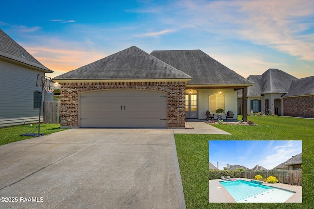 105 Hazy River Way, Lafayette, LA 70508 - french country inspired facade featuring a shingled roof, brick siding, an attached garage, and driveway