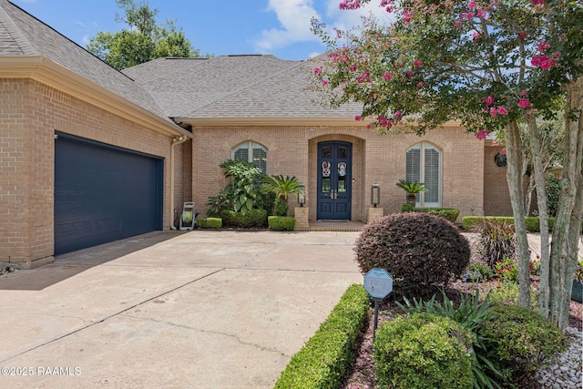 102 Capilano Ln, Broussard, LA 70518 - view of front of property featuring roof with shingles, brick siding, a garage, and concrete driveway