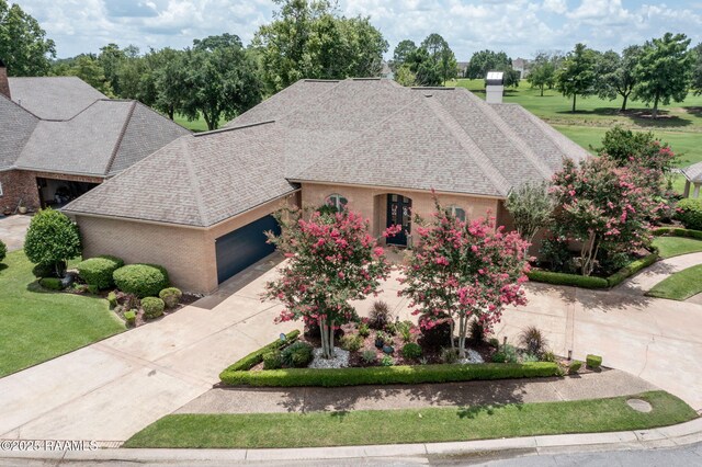 102 Capilano Ln, Broussard, LA 70518 - french provincial home with a garage, a chimney, a shingled roof, and driveway