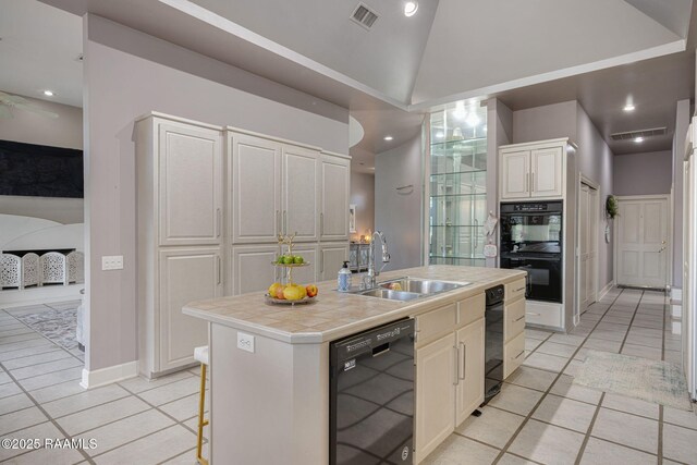 102 Capilano Ln, Broussard, LA 70518 - kitchen featuring black appliances, light tile patterned floors, a kitchen island with sink, tile countertops, and lofted ceiling