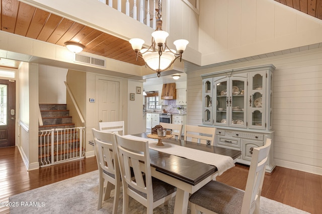 1714 Christopher Fox Ln, New Iberia, LA 70563 - dining space with healthy amount of natural light, wood finished floors, a chandelier, wood walls, and baseboards