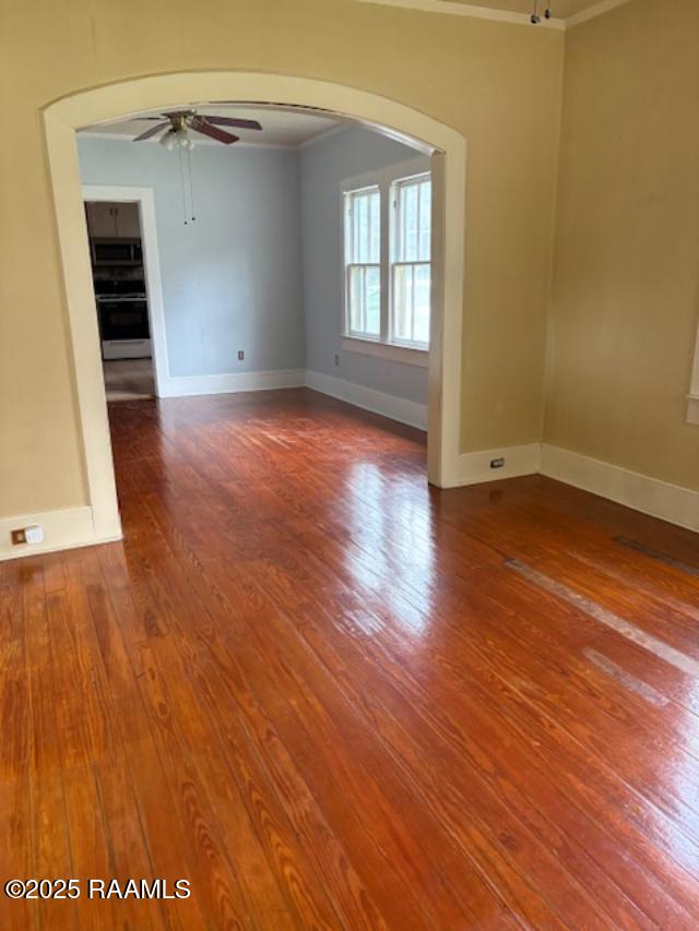 700 S State St, Abbeville, LA 70510 - unfurnished room with ceiling fan, ornamental molding, hardwood / wood-style flooring, baseboards, and arched walkways