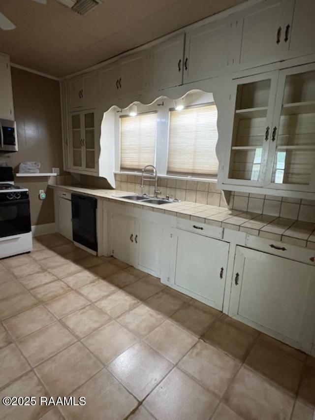 700 S State St, Abbeville, LA 70510 - kitchen featuring a sink, electric range oven, dishwasher, stainless steel microwave, and tile countertops