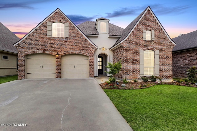 111 San Sebastian Dr, Youngsville, LA 70592 - french country style house featuring brick siding, concrete driveway, a front lawn, roof with shingles, and a garage