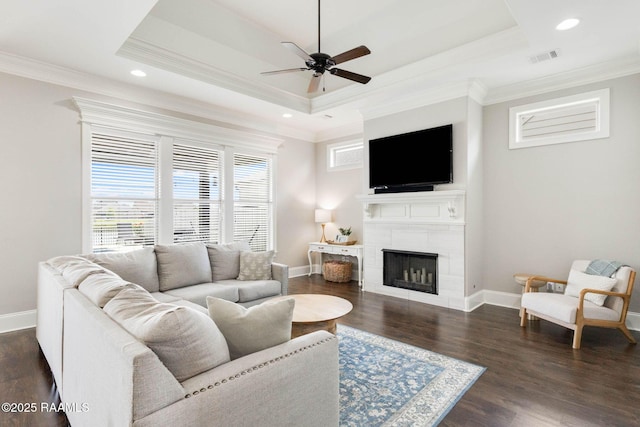 111 San Sebastian Dr, Youngsville, LA 70592 - living area with a tray ceiling, crown molding, ceiling fan, a tile fireplace, and dark wood-style floors