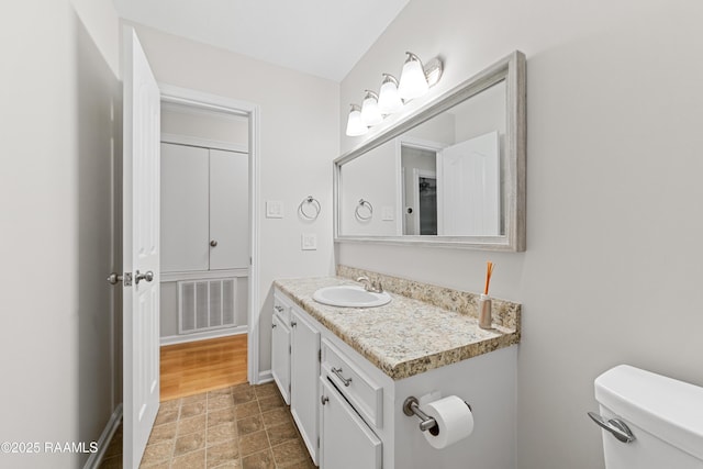315 Kelso Dr, Carencro, LA 70520 - bathroom with vanity, toilet, stone finish flooring, and baseboards