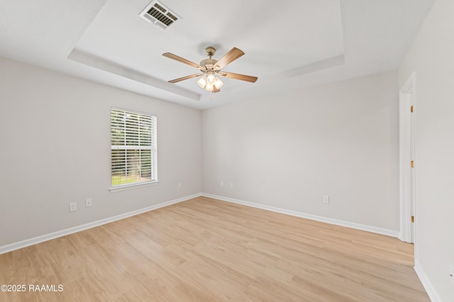 315 Kelso Dr, Carencro, LA 70520 - spare room featuring a tray ceiling, light wood-style floors, a ceiling fan, and baseboards
