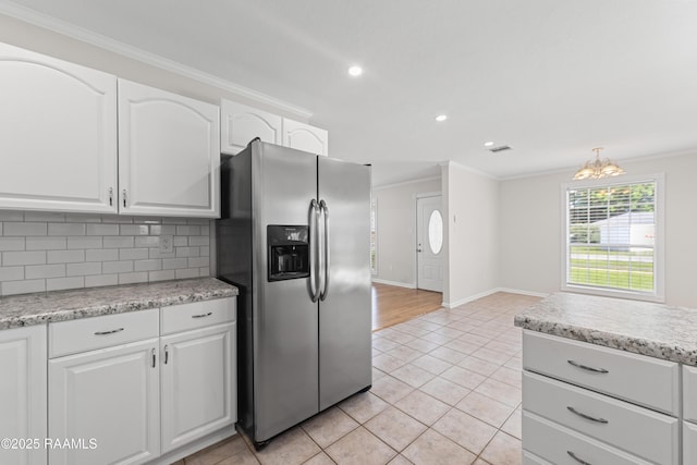315 Kelso Dr, Carencro, LA 70520 - kitchen featuring stainless steel fridge, ornamental molding, white cabinetry, tasteful backsplash, and light tile patterned floors