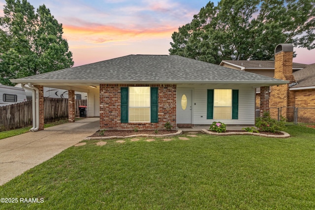 315 Kelso Dr, Carencro, LA 70520 - view of front facade with roof with shingles, concrete driveway, a carport, and brick siding
