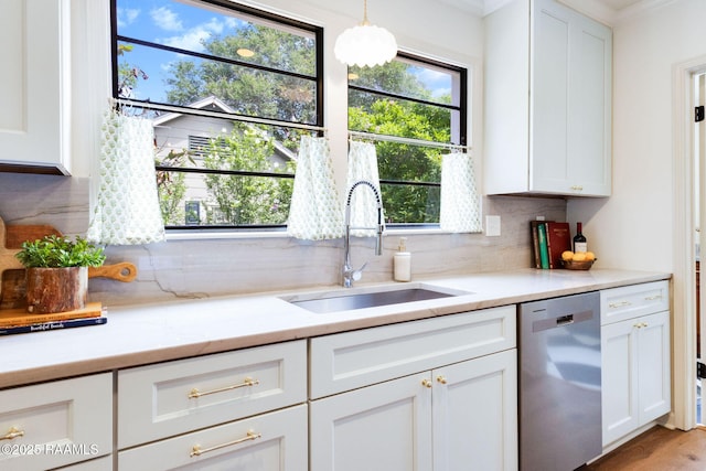 809 Saint Thomas St, Lafayette, LA 70506 - kitchen with stainless steel dishwasher, a sink, backsplash, white cabinets, and decorative light fixtures