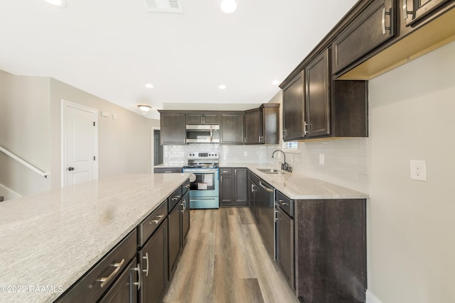 119 Sandstone Ave, Scott, LA 70583 - kitchen featuring appliances with stainless steel finishes, a sink, light wood finished floors, dark brown cabinetry, and light stone counters