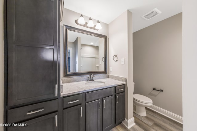 119 Sandstone Ave, Scott, LA 70583 - bathroom with wood finished floors, toilet, vanity, and baseboards